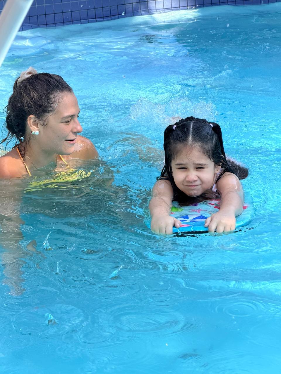 Child swimming towards her coach