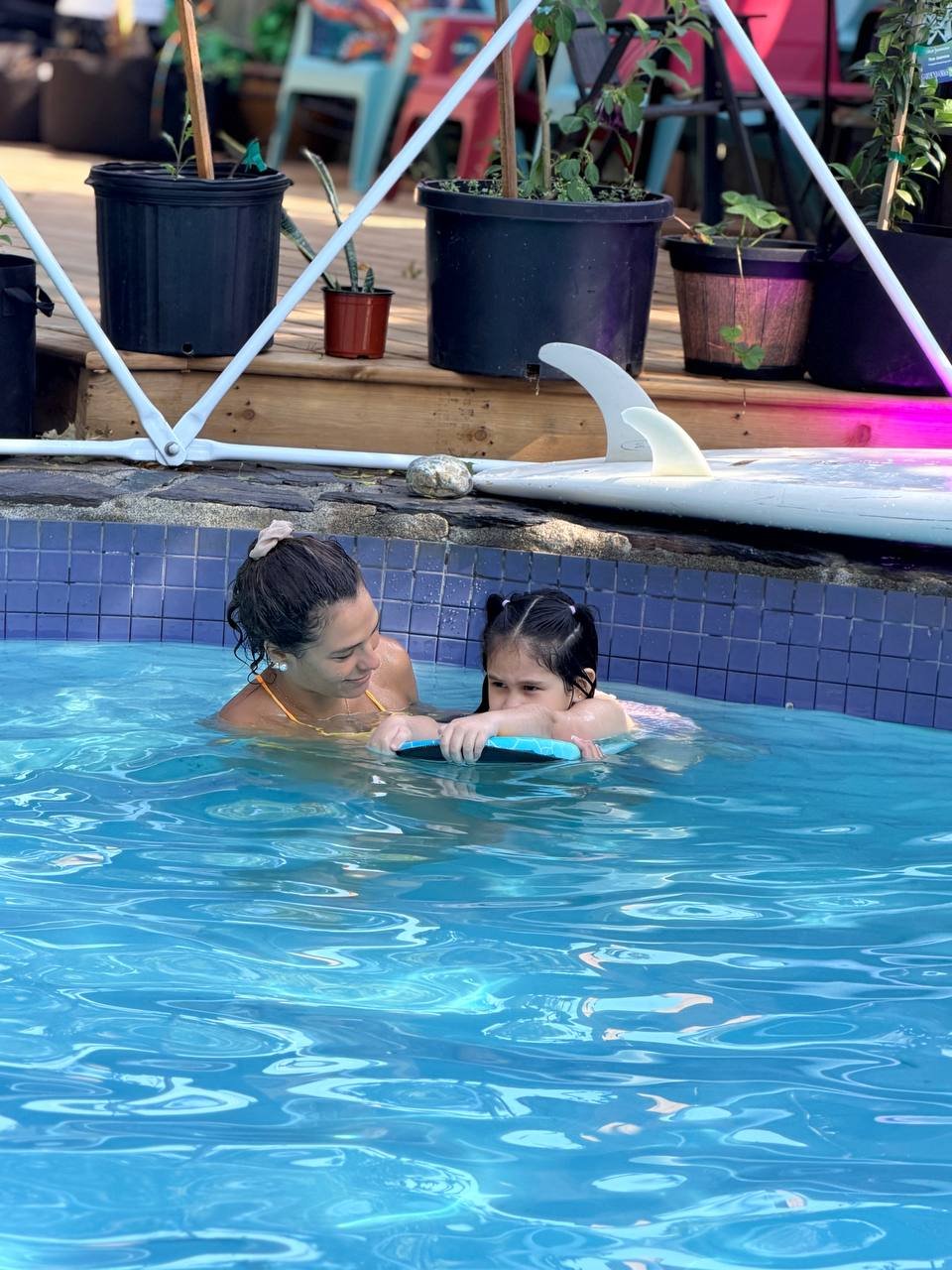 Coach and student stretching arms overhead in the water